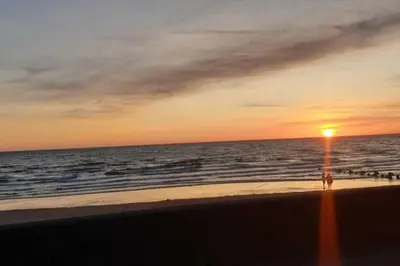 a sunset on the beach with a light pole at Seaview Apartment Sleeps 2 -Patio -WiFi -Tv in Barmouth