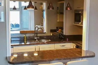 a kitchen with a sink and a microwave at Seaview Apartment Sleeps 2 -Patio -WiFi -Tv in Barmouth