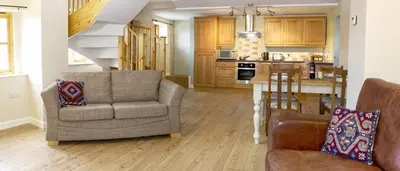 a living room with two chairs and a table and a kitchen at Finest Retreats - 2 Bed Llangollen Cottage - Sleeps 4 in Llangollen