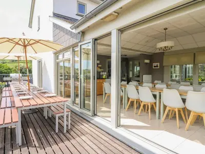 a patio with a table and chairs on a deck at Llety Ceiro in Bow Street