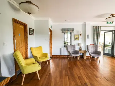 a living room with chairs and a table at Llety Ceiro in Bow Street