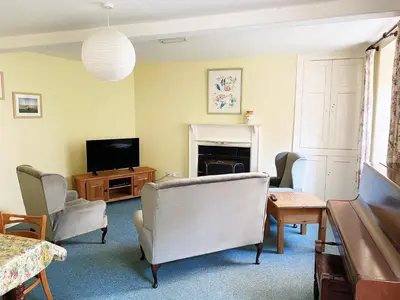 a living room with a tv and a couch and chairs at Plas Dolau Country Estate in Aberystwyth