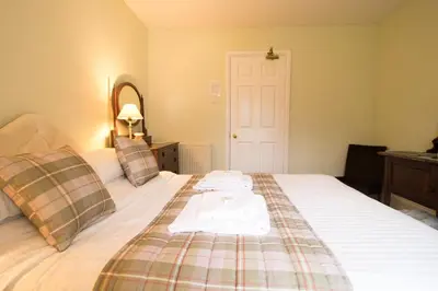 a bedroom with a bed with two towels on it at Plas Dolau Country Estate in Aberystwyth