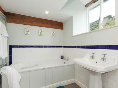 a white bathroom with a tub and a sink at Rhydleos Mill in Llansilin