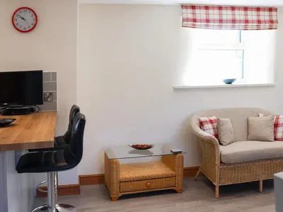 a living room with a chair and a table at Bwthyn Glanllyn in Llanuwchllyn