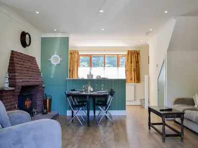 a living room with a table and a fireplace at Ty Cregyn - Uk11957 in New Quay