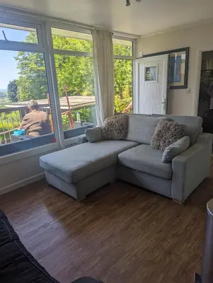 a living room with a couch and large windows at Springside Chalet20 in Tywyn