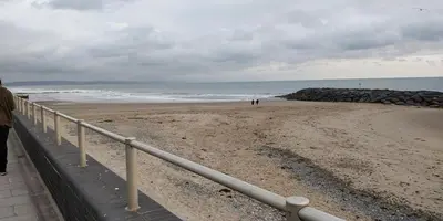 a beach with people walking on the sand at Springside Chalet20 in Tywyn