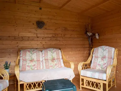 two wicker chairs sitting in a log cabin at Kinverley in Evenjobb