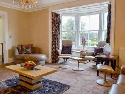 a living room filled with furniture and a large window at Maesbangor Farmhouse in Capel Bangor