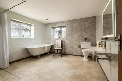 a bathroom with a tub and a toilet and a sink at Pendennis at Eaton Manor in Church Stretton