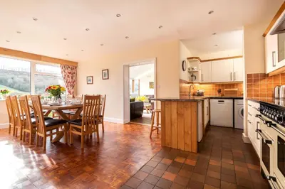 a kitchen and dining room with a table and chairs at Pendennis at Eaton Manor in Church Stretton