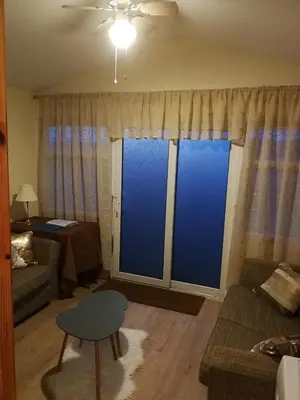 a living room with a couch and a large window at Chalet Kiss of the Sea in Aberystwyth