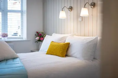 a white bed with a yellow pillow on it at Cherry Orchard in Shrewsbury