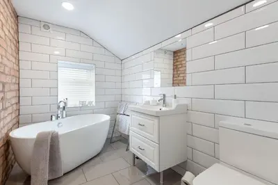 a white bathroom with a tub and a sink at Cherry Orchard in Shrewsbury