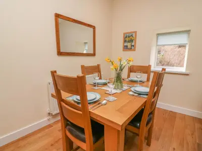 a dining room table with chairs and a mirror at Y Felin - Celyn in Borth