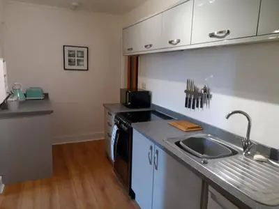 a kitchen with a sink and a counter top at Ground Floor Barmouth Centre Apartment With Garden in Barmouth