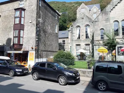 a group of cars parked in front of buildings at Ground Floor Barmouth Centre Apartment With Garden in Barmouth