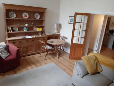a living room with a table and a dining room at Ground Floor Barmouth Centre Apartment With Garden in Barmouth