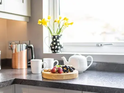 a kitchen counter with a plate of fruit on a cutting board at Cartref in Trawsfynydd