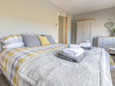 a bedroom with a bed with towels on it at Cartref in Trawsfynydd