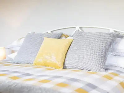 a bed with blue and yellow pillows on it at Cartref in Trawsfynydd
