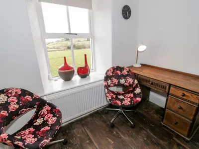 an office with two chairs and a desk and two windows at Cefn Nannau in Corwen