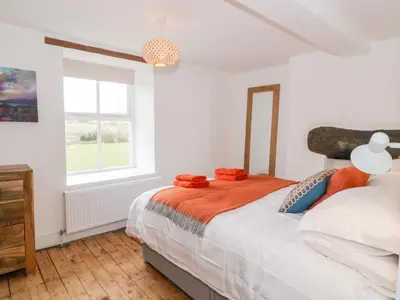 a bedroom with a bed and a window at Cefn Nannau in Corwen