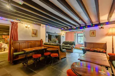 a bar with tables and chairs in a room at Pen-Y-Bont Hotel in Tal-y-llyn