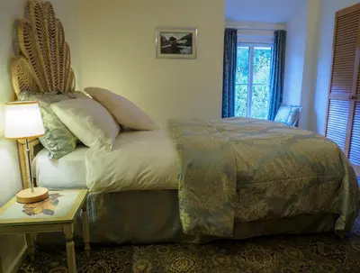 a bedroom with a bed and a table with a lamp at Pen-Y-Bont Hotel in Tal-y-llyn