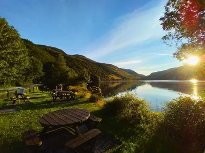 a picnic table with a view of a lake at Pen-Y-Bont Hotel in Tal-y-llyn