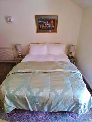 a large bed in a bedroom with two lamps at Pen-Y-Bont Hotel in Tal-y-llyn
