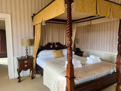 a bedroom with a four poster bed with a canopy at Netley Hall in Shrewsbury