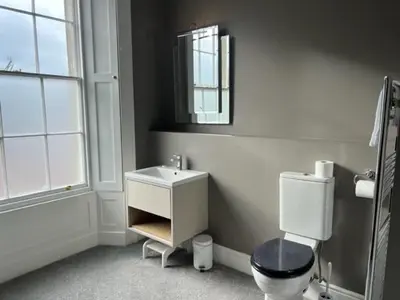 a bathroom with a toilet and a sink and a mirror at Netley Hall in Shrewsbury