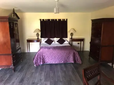 a bedroom with a bed with a purple bedspread at Netley Hall in Shrewsbury