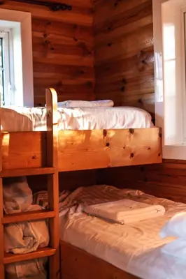 two bunk beds in a room with wooden walls at Rustic Log cabin in Snowdonia By Seren Short Stays in Trawsfynydd