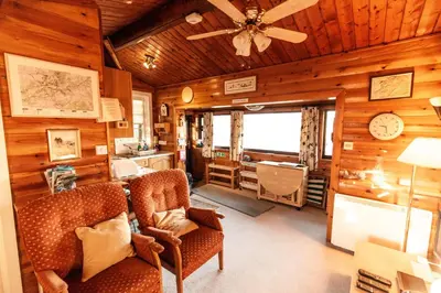 a living room with wooden walls and a ceiling at Rustic Log cabin in Snowdonia By Seren Short Stays in Trawsfynydd