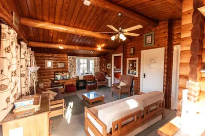 a log cabin living room with a ceiling fan at Log Cabin nr Coed y brenin By Seren Short Stays in Trawsfynydd