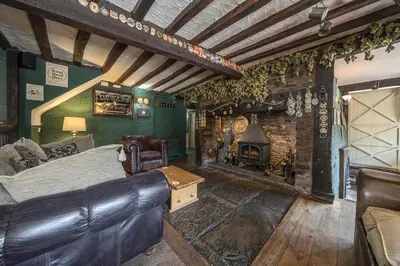a bedroom with a bed and a stone fireplace at The Boars Head Pub in Bishops Castle