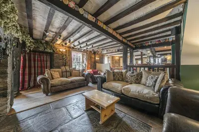 a living room with leather couches and a table at The Boars Head Pub in Bishops Castle