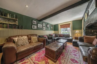 a living room with leather furniture and a fireplace at The Boars Head Pub in Bishops Castle
