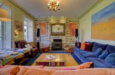 a living room with a blue couch and a stone fireplace at Borthwnog Hall in Dolgellau