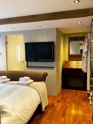 a bedroom with a bed and a flat screen tv at Borthwnog Hall in Dolgellau