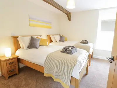 a bedroom with two beds and a window at Bryn Mawndy in Corwen