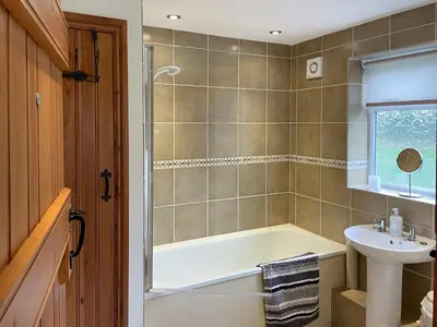 a bathroom with a bath tub and a sink at Herrock View in Evenjobb
