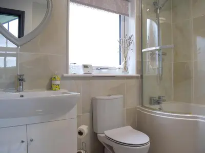 a bathroom with a toilet and a sink and a tub at Bumble Lodge in Llynclys