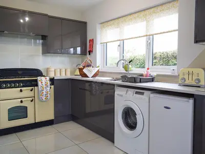 a kitchen with a washing machine and a washer at Bumble Lodge in Llynclys