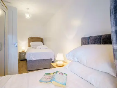 a bedroom with two beds and a mirror at Fron Towyn Cottage in New Quay