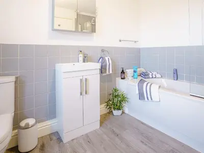 a bathroom with a sink and a tub and a toilet at Fron Towyn Cottage in New Quay