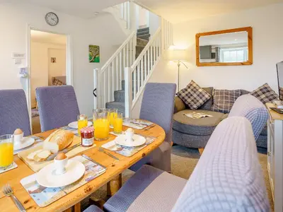 a living room with a table and chairs at Fron Towyn Cottage in New Quay